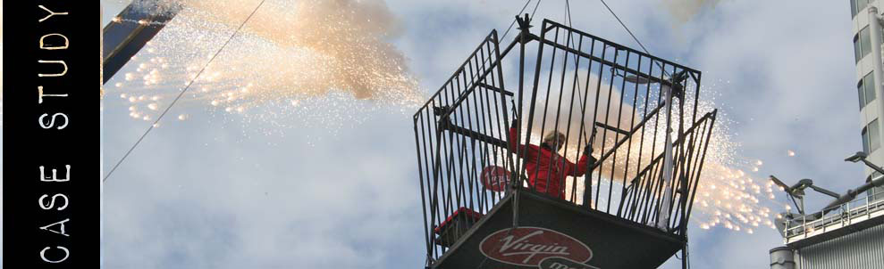 A few years ago the Danger Boy team had the fantastic opportunity to work with Sir Richard Branson and the Virgin Mobile Group to create a dynamic stunt for their “Escape Your Cell” live event.  We were asked to both stunt coordinate, rig and fabricate all the props for a live stunt to be performed by Branson himself.  The show was to be held at Yonge-Dundas Square in the heart of downtown Toronto.